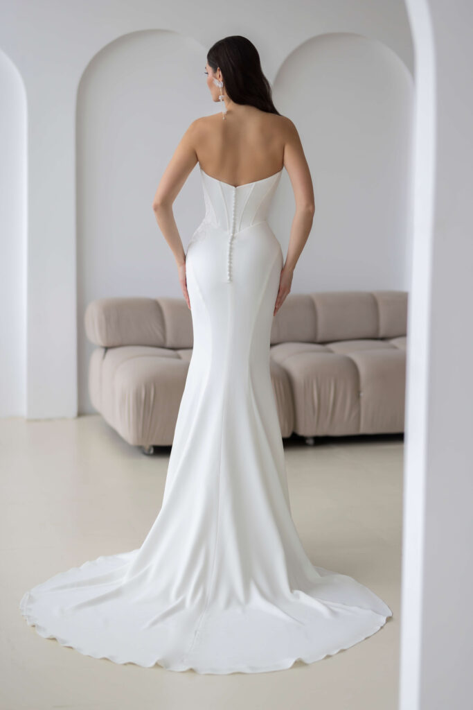 Rückenansicht eines figurbetonten Clean Brautkleides mit Schleppe